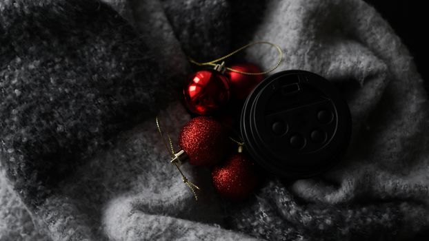 Coffee Cup with red Christmas balls on a grey background. Christmas composition. A festive concept for a coffee shop.