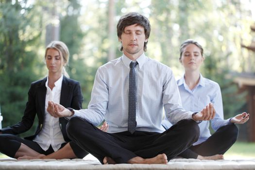 Business people team practicing yoga in park