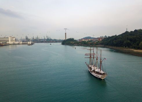 SINGAPORE - CIRCA MARCH 2019: Aerial view of an old sailing boat entering Keppel Bay.