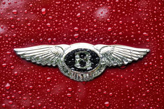 LONDON, UK - CIRCA SEPTEMBER 2011: Bentley logo on red car. Raindrops on bodywork and logo.