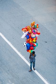 PATAN, NEPAL - 19 APRIL, 2018: Young Nepalese man selling balloons during Rato Machindranath chariot procession.