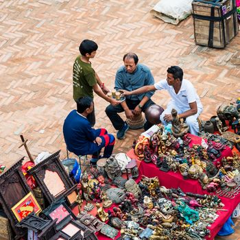 KATHMANDU, NEPAL - CIRCA APRIL 2018: A boy serves tea to souvenir sellers at Kathmandu Durbar Square.