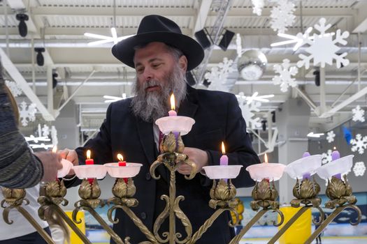 02.09.2019 Kiev, Ukraine. the chief rabbi of the city of Kiev Jonathan Markovich lights candles with children at the festival of Hanukkah