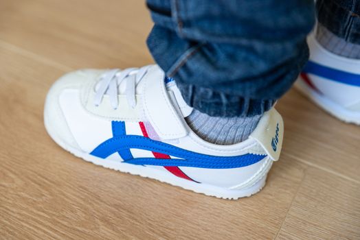 BAYONNE, FRANCE - CIRCA MAY 2020: Little boy wears Onitsuka Tiger Mexico 66 TS kid's shoes.