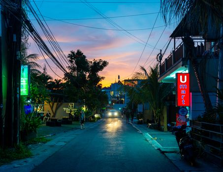 SEMINYAK, INDONESIA - CIRCA MARCH 2019: Small street at sunset. Seminyak is a popular tourist destination in Bali.