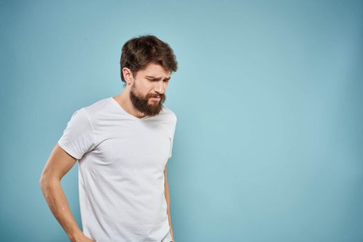 Man in white t-shirt emotions facial expression cropped view studio blue background lifestyle. High quality photo
