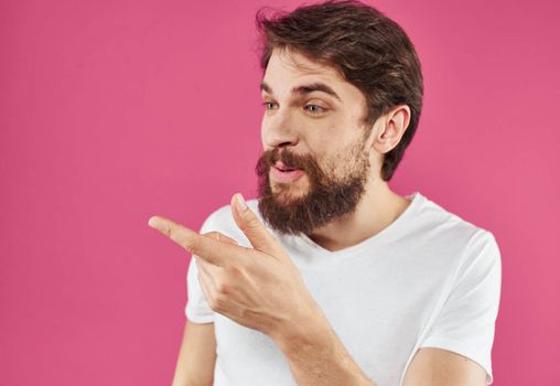 Cute guy with beard on pink background close-up portrait cropped view. High quality photo