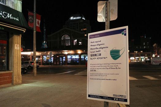 Ottawa, Ontario, Canada - November 15, 2020: A multilingual Ottawa Public Health sign in the ByWard Market indicates that face masks are required according to city by-law.