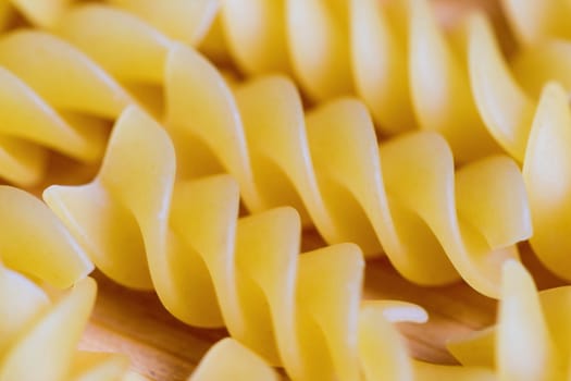 Closeup view of raw pasta on wooden background.