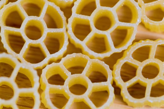 Closeup view of raw pasta on wooden background.