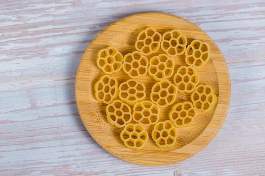 Closeup view of raw pasta on wooden background.