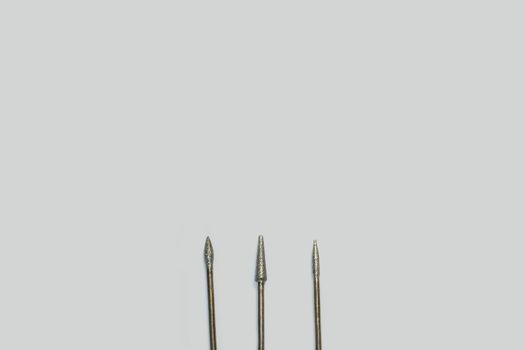 Set of three milling cutters. Manicure tool. Used manicurist professional tools on a white background with free space for text.