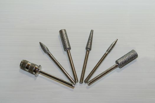 Set of six milling cutters. Manicure tool. Used manicurist professional tools on a white background.