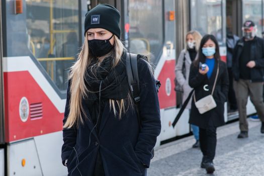 11/16/2020. Prague. Czech Republic. A woman wearing a mask is getting of the tram at Hradcanska tram stop during quarantine. This is a lockdown period in the Czech Republic due to the increase of COVID-19 infectious in the country. Hradcanska tram stop it is in Prague 6