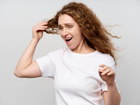 Elderly woman holding her hair in white t-shirt Lifestyle Studio