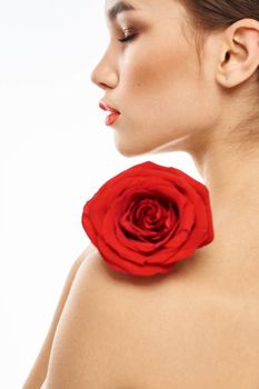 Portrait of woman with red rose naked shoulders Make-up on brunette face. High quality photo