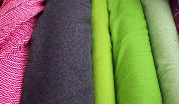 Detailed close up view on samples of cloth and fabrics in different colors found at a fabrics market.