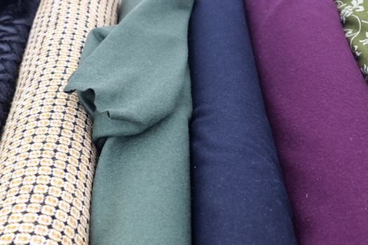 Detailed close up view on samples of cloth and fabrics in different colors found at a fabrics market.