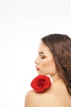 Portrait of woman with red rose naked shoulders Make-up on brunette face. High quality photo