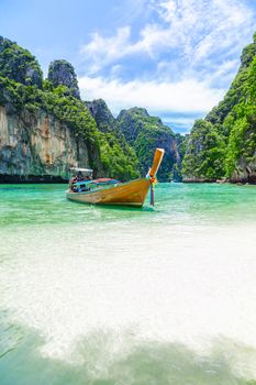 Thai traditional wooden longtail boat and beautiful beach in Phuket province, Thailand.