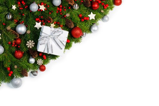 Christmas corner Border frame of tree branches isolated on white background with copy space , red and silver decor, berries, stars, cones, gift box