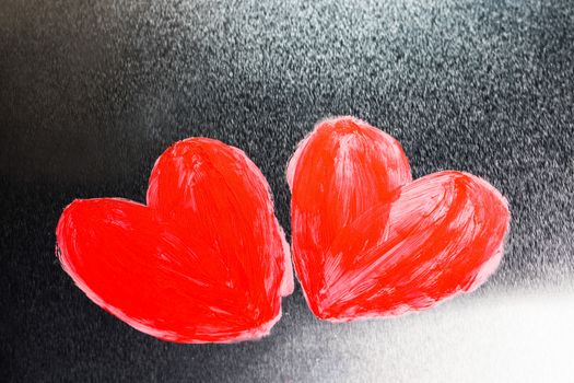 Two abstract red painted hearts on metal background