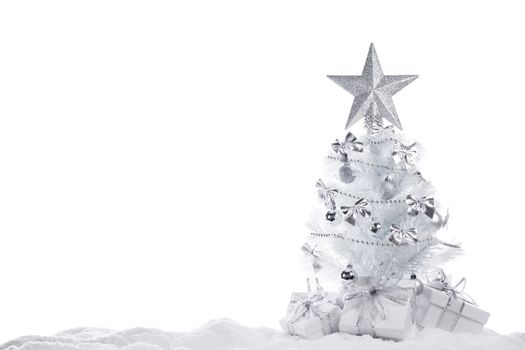White christmas tree with silver decorations and gifts isolated on snow on white background