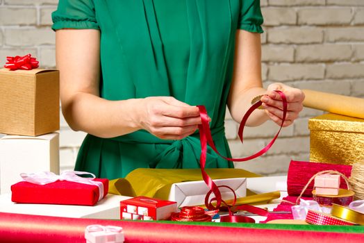 Gift wrapping for Christmas and New Year. Handmade. Gift wrapping for Christmas and New Year. Handmade. girl's hands with gift ribbon, twine, tape. gifts wrapping concept