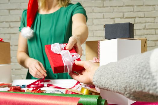 Close Up on hands women hands holding and giving red gift box with white ribbon to girl. Birthday, Christmas, Mother's day and New year present box.