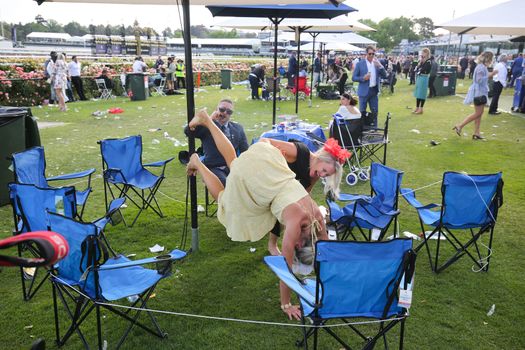 MELBOURNE, AUSTRALIA - NOVEMBER 05, 2019: Drunnk punters at the end of the Lexus Melbourne Cup Day at the 2019 Melbourne Cup Carnival at Flemington Racecourse in Melbourne Australia