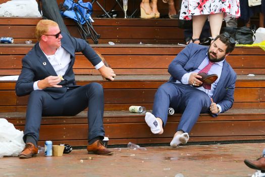 MELBOURNE, AUSTRALIA - NOVEMBER 6: A drunk punter removes his socks at the end of the day during the Lexus Melbourne Cup Day at the 2018 Melbourne Cup Carnival