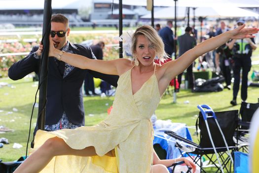 MELBOURNE, AUSTRALIA - NOVEMBER 05, 2019: Drunnk punters at the end of the Lexus Melbourne Cup Day at the 2019 Melbourne Cup Carnival at Flemington Racecourse in Melbourne Australia