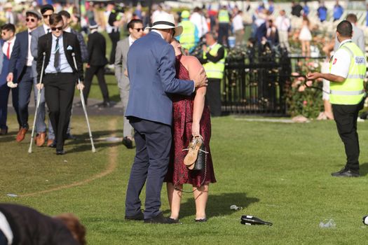 MELBOURNE, AUSTRALIA - NOVEMBER 05, 2019: Drunnk punters at the end of the Lexus Melbourne Cup Day at the 2019 Melbourne Cup Carnival at Flemington Racecourse in Melbourne Australia