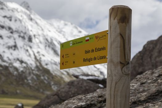 GR route sign indicating the distance and time to the Estanes lake and the Lizara refuge, Aguas Tuertas valley, Hecho, Anso, Huesca. Aragonese Pyrenees.