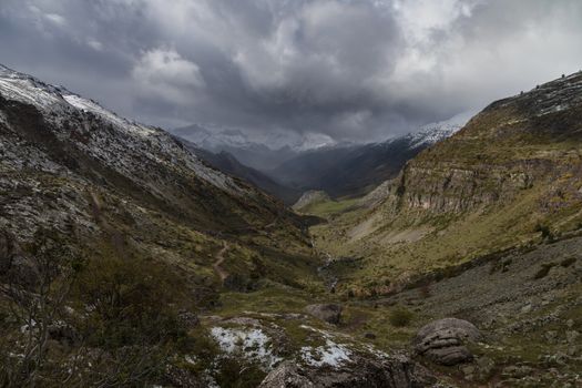 Snowy mountains landscape in the Aragonese Pyrenees. Cloudy view of the Guarrinza pastures, near of Aguas Tuertas valley, Hecho and Anso, Huesca, Spain.