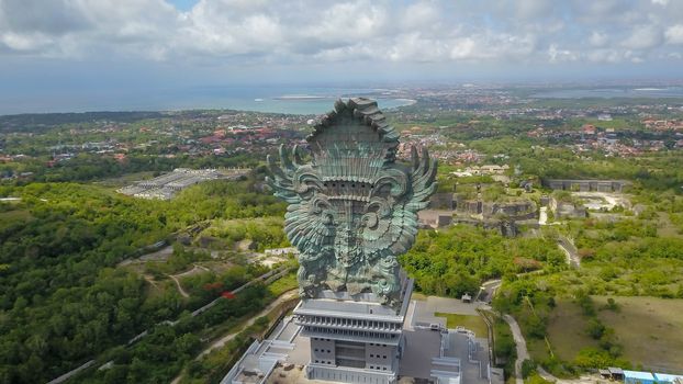 Landscape picture of tallest Garuda Wisnu Kencana GWK statue as Bali landmark with blue sky as a background. Balinese traditional symbol of hindu religion. Popular travel destinations in Indonesia.