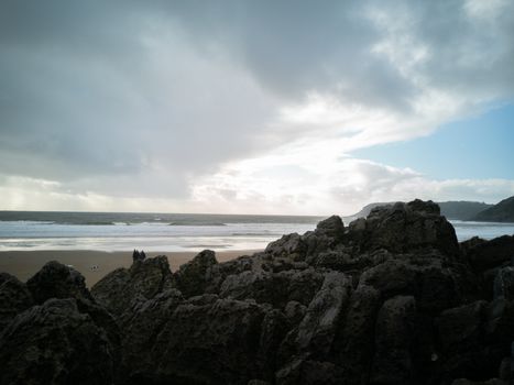 Overlooking the ocean from the rocks on a cloudy day at Caswell Bay Beach towards winter.