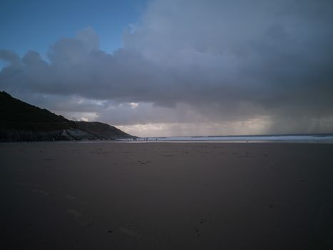 Stormy Skies with torrential downpour out at sea at Caswell Bay in Gower, Wales, UK. Rain on the beach in late Autumn.