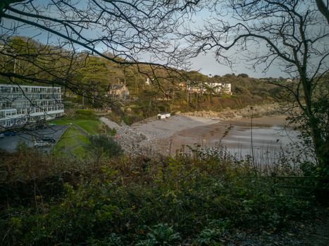 Looking down on Caswell Bay Beach from the Gower Coastal Path in late Autumn. Trees without leaves and rich colours.