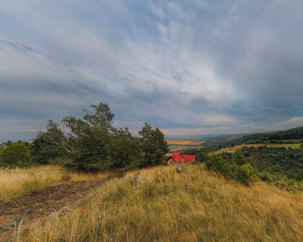 Panorama of cloudy afternoon at mountains with red roof building