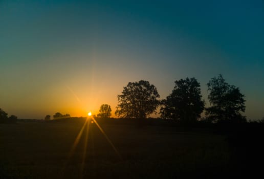 Rising sun over dark horizon seen by star filter