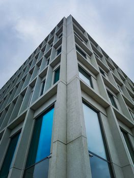 Upward view to corner of concrete corporate building with huge windows