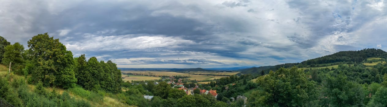 Panoramic view of small village in mountains and a lot of fields