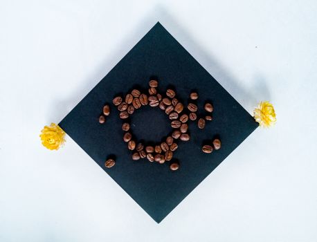 Circle of coffee on square paper card with flowers at corners