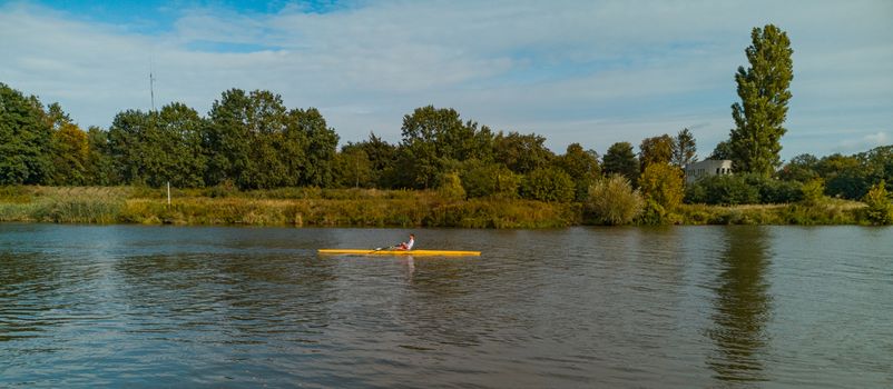 Man swimming on yellow kayak on Odra river