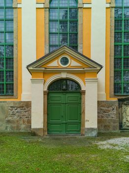 Green entrance doors to old big building with huge windows