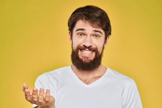 Bearded man in white t-shirt emotions close-up fun yellow background. High quality photo