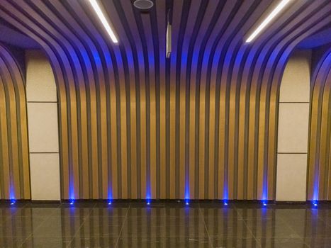 Higlighted colorful wall with blue lights and black tiles on floor