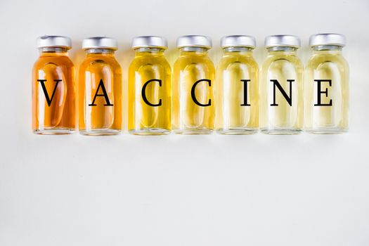 New vaccine in ampules, different color variations of vaccine on the white background, bottle and liquid drug, Corona virus