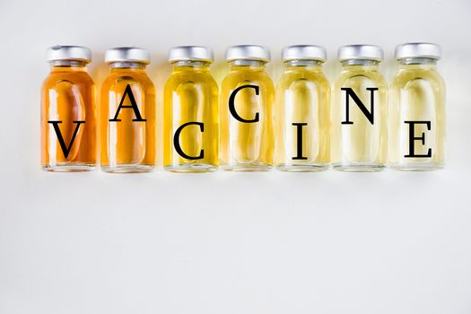 New vaccine in ampules, different color variations of vaccine on the white background, bottle and liquid drug, Corona virus